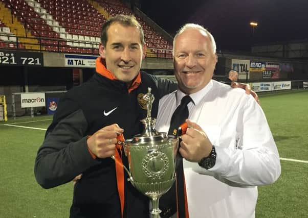 David Hilditch and first-team coach Gary Haveron with the Intermediate Cup - one of three trophies the club won last season.