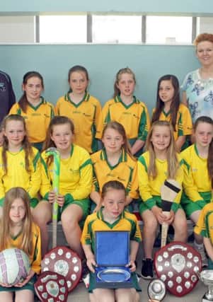 GREAT SPORTS. St Brigid's PS Camogie, Netball and Hockey teams with their array of trophies along with coaches Diane Kirgan and Leona Campbell.INBM25-15 068SC.
