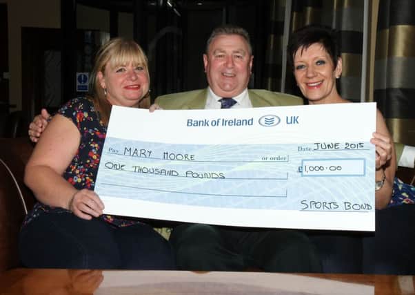 Sports Bond £1,000 jackpot winner Mary Moore receives her award from winning agent Julie Moore and Sports Bond promoter Brian Thompson. Picture: Reid McAuley.