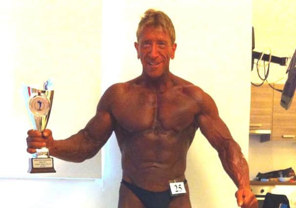 Bodybuilder Jim Henderson, pictured with his sixth-place NABBA World Championship trophy on the night before his death. INCT-25-701-con