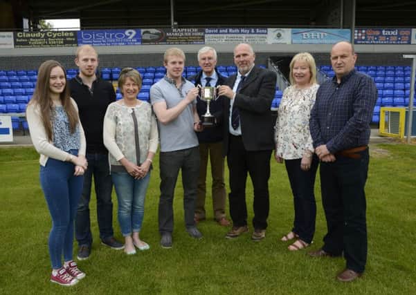 The family of the late Ian Crown, from left, Kathy Crown, Dean Crown, Janine Crown, Graham Crown, Hilary Dickson and Leslie Dickson, handing over the Graham Crown Memorial Cup to Bill Anderson, third from right, Chairman, and Charlie Ferguson, fourth from right, President of Institute Football Club. INLS2415-189KM