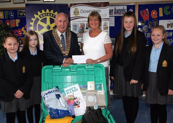 Carrickfergus Rotary Club president Sam Crowe receives a cheque for the purchase of a ShelterBox for Nepal from Downshire School principal Mrs Jackie Stewart.  Also pictured are some of the pupils who led the fundraising efforts.  INCT 27-721-CON