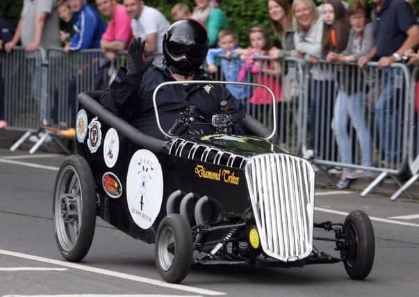 Waving to the crowd during the soapbox derby at the Arches Festival. INAT27-423AC