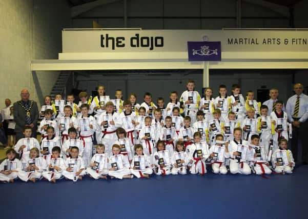 Junior members of The Dojo who received their white, green and yellow belts at their recent grading. Included are Mayor of Mid and East Antrim Council, Cllr. Billy Ashe, who officially opened the club's Woodside Road premises and head coach David Toney. See page 56 for more ocverage of the opening. INBT27-220AC