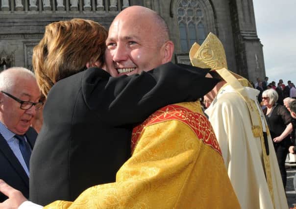 Fr Brian Slater is congratulated by a family member after Sunday's ordination service.INTT2715-382