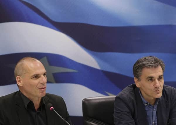 Outgoing Greek Finance Minister Yanis Varoufakis, left, speaks as the new Finance Minister Euclid Tsakalotos listens to him during a hand over ceremony in Athens, Monday, July 6, 2015. Following Sunday's referendum the Greece and its membership in Europe's joint currency faced an uncertain future Monday, with the country under pressure to restart bailout talks with creditors as soon as possible after Greeks resoundingly rejected the notion of more austerity in exchange for aid. (AP Photo/Petr David Josek)