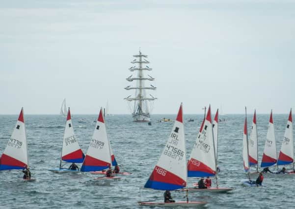 One of the Tall Ships appears on the horizon as competitors take part in the Irish Topper National Championships at County Antrim Yacht Club, Whitehead. INLT 28-943-CON