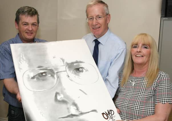 Gregory Campbell is presented with a painting of himself from artist Oliver McParland that was one of many paintings he had on display during his exhibition at the Millenium Forum. Included is Mrs Pauline McParland. INCR28-338PL