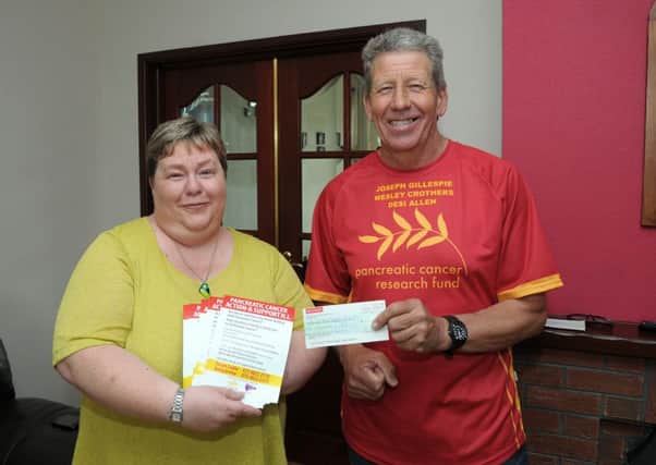 Brian Crothers hands over a cheque for £2,068 to Susan Cooke from the Pancreatic Cancer Research Fund. INNT 26-215-AM