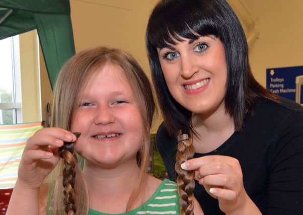 Deed Done...Lyla Copeland (8) and Regis stylist Lyndsey Beggs pictured with two16 inch pigtails which Lyla had cut off for the Little Princess charity. INLM29-210.