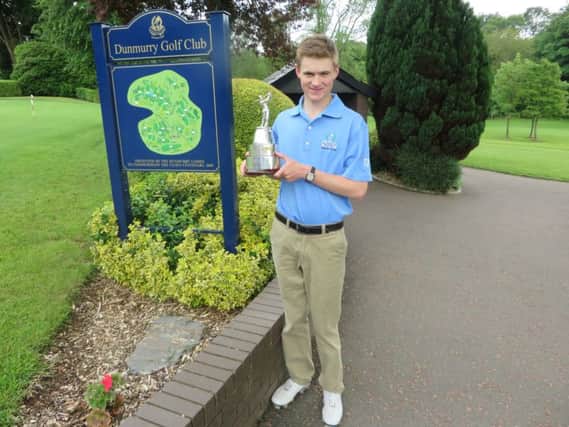 Dunmurry golfer Peter Kerr shows off his Ulster Boys trophy.