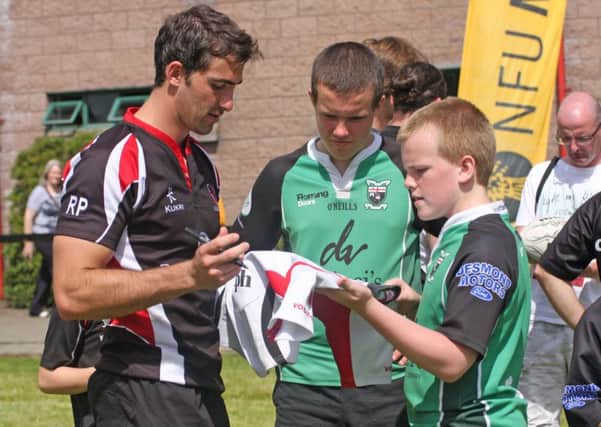 SIGN HERE!. . . .Ulster's Ruan Pienaar signs a jersey for brothers Corey and Craig Logan during Thursday's training session at Judges Road. 2707JM66