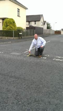 Councillor Mark Baxter with the pothole at Baird Avenue.