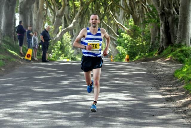 Brian Campbell winner of the Half Marathon leads the runners through the Dark Hedges