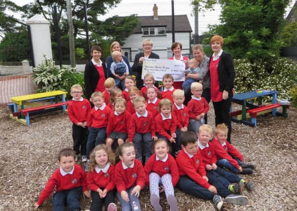 Roma Brown of the Larne Support Group for Northern Ireland Hospice is pictured with Lorraine, Anita, Karen and all the children from the Glynn Hansel & Gretel Pre School Group, receiving a cheque for £404 for the Northern Ireland Hospice. The money was raised at a coffee morning where lots of cakes and buns were sold and put in boxes decorated by the children. INLT 31-626-CON