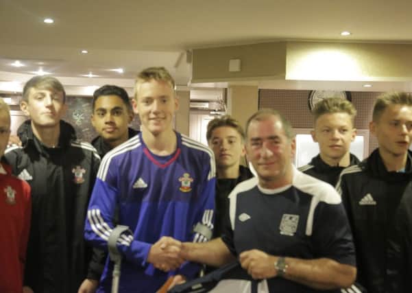 Southampton goalkeeper Jack Bycroft receives a presentation from County Down Milk Cup chairman Paul Ritchie along with players of both Down and Southampton