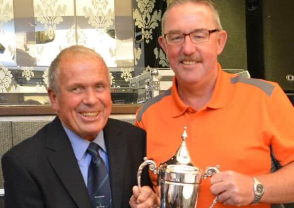 Silverwood Captain Peter Graham presents the top prize to Gerry Beattie.