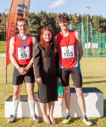 Pictured with Paula Simpson of firmus energy are Ciaran Barnes (left) and Adam Hill both from City of Lisburn Athletic Club who came first and second respectively in the Senior Men 400m hurdles.