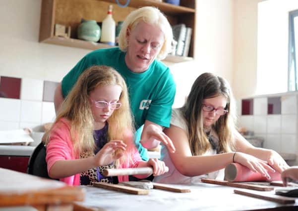 Donna McNicholl, Youth Officer, RNIB NI, helping Shauna, left, and Leagh, right, with their pottery session at Share Discovery Village, Lisnaskea as part of the Angel Eyes NI and Share summer scheme. Photo: Michael Cooper