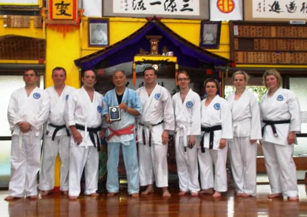 Chujo Karate Association members present an engraved plaque to Hanshi Tetsuhiro Hokama at his Okinawa Dojo.
