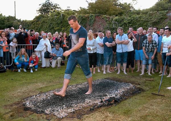 Supporters, family friends and fellow firewalkers look on as the firewalk raises funds for the support of Limavady resident Sean McKeever in need of equipment enabling dialysis at home while he awaits a kidney transplant. Donations were also for the support of the Renal Unit at Altnagelvin Hospital. INLV3215-171KDR