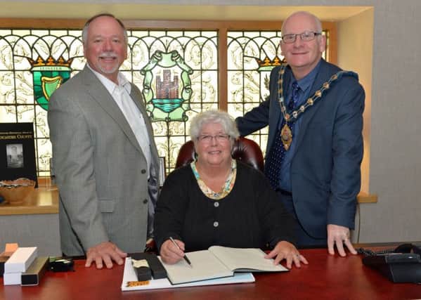 Ron Scott, City Manager of Danville and his wife, Janis sign the visitors' book in the mayors parlour during their visit to Carrickfergus.  Also pictured is Mid and East Antrim Bourough Council Mayor Billy Ashe. INCT 31-001-PSB