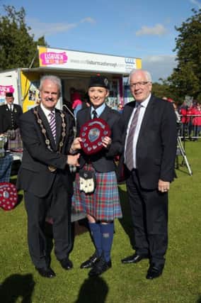Mayor of Lisburn & Castlereagh City Council, Councillor Thomas Beckett, Chair of the Development Committee, Alderman Allan Ewart congratulates local Drumlough Pipe Band drum major Lauren Hanna on her success in the Adult section of the 2015 Lisburn & Castlereagh Pipe Band Championships.
