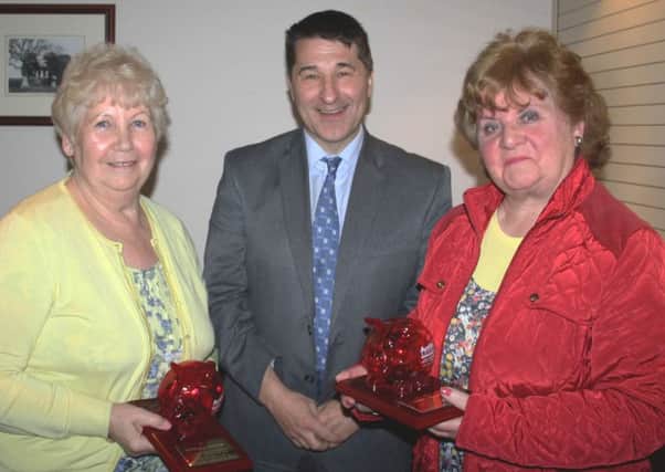 Gareth Kirk, chief executive of Action Cancer, presents plaques to Monena Gibson (left) and Vikki Dundas. INNT 32-501CON