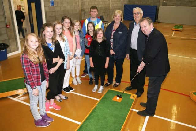 Danny Kinahan MP has a go at crazy golf at the Neillsbrook Community Development Group summer scheme as looking on are Cllr. Linda Clarke, Cllr. Drew Ritchie and scheme members and leaders. INBT32-221AC