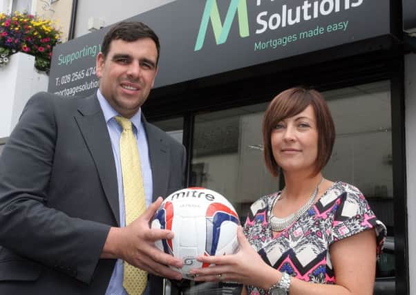 Lynsey Hyndman of Mortgage Solutions presents a sponsored ball to Stewart McDonald of Ahoghill Thistle. INBT33-211AC