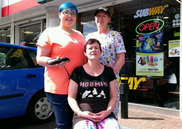 Sharon Cowan (seated) gets ready to have her head shaved by Subway colleague Joleen Carlisle (left) and store manager Suzan Campbell. INNT 33-510CON