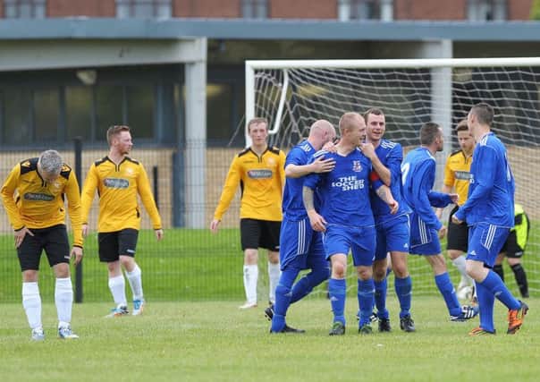 Rathfern captain Philip Gordon is congratulated by his team-mates after scoring the first of his two goals in their 3-2 win over Sirocco Works. INLT 33-905-CON Photo: Philip McCloy