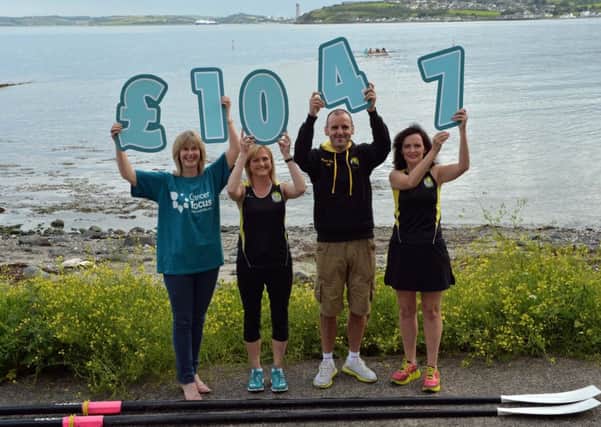 Marie Foy (left) from Cancer Focus Northern Ireland accepts the sum of £1,047 from East Coast Athletic Club members, Cate Devine, Justin Maxwell and Linzi Conway who were part of a 15 strong team who took part in the charity`s Dragon Boat race on the River Lagan in memory of Cate`s sister, Esme-Marie McManus. INLT 32-012-PSB