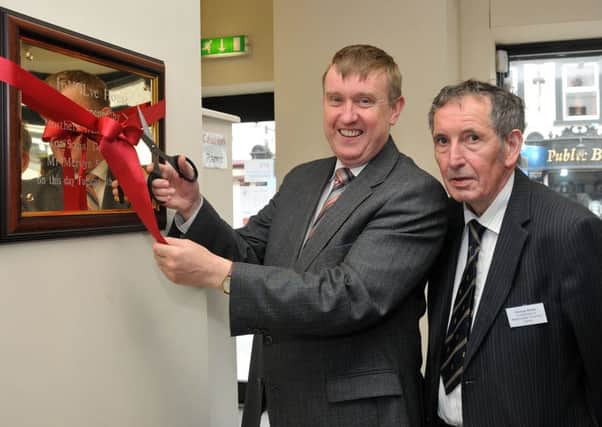 Minister for Social Development Mervyn Storey  cuts the ribbon to officially open Involve House Magherafelt on Tuesday afternoon of this week as Cookstown & Magherafelt Volunteer Centre Chairperson George Shiels looks on.INMM3115-332