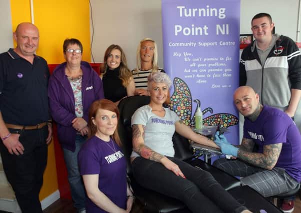 Tattooist Richard Wylie and Nicole Gibson (third left) of Clockwork Tattoo (Wellington Street) along with members of Turning Point NI during their "Semi Colon" project. Customers can get a semi colon tattoo for £15, with £10 being donated to Turning Point NI. INBT34-250AC