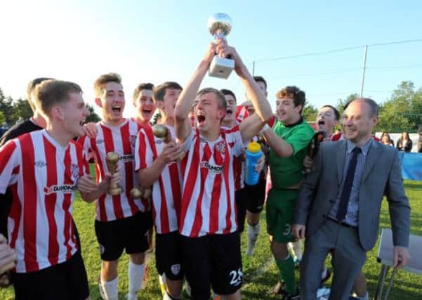 Derry City's Ciaron Harkin holds aloft the Hughes Insurance Foyle Cup U19 trophy.