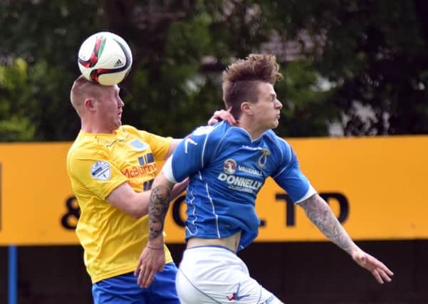 Kyle McVey wins a header against Swifts' Paul McElroy. Pictures: Press Eye.