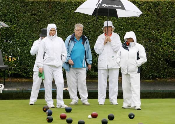 Ballymena and Dunluce bowlers try to keep dry during their match. INBT35-207AC