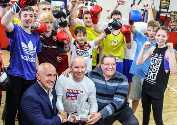 Barry McGuigan hands over the National Lottery Award to Paul Johnston (project manager), Billy Snoddy (chairman) and delighted young boxers at Monkstown Boxing Club. INNT 35-501-SO