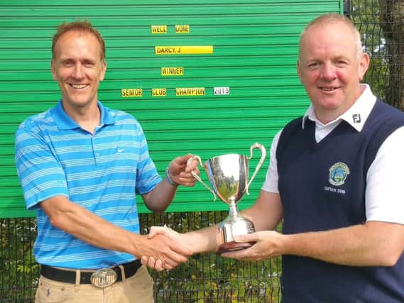 John D'Arcy receives the Seniors Club Championship trophy from Rockmount GC Captain Eddie Donaldson.