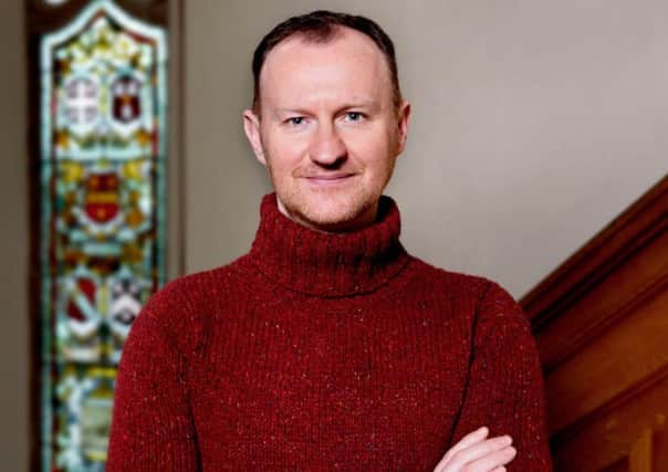 Writer and actor Mark Gatiss pictured in Derry's Guildhall with its distinctive stained glass windows behind him.