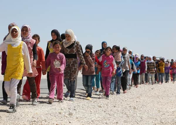 Syrian children march in the refugee camp in Jordan