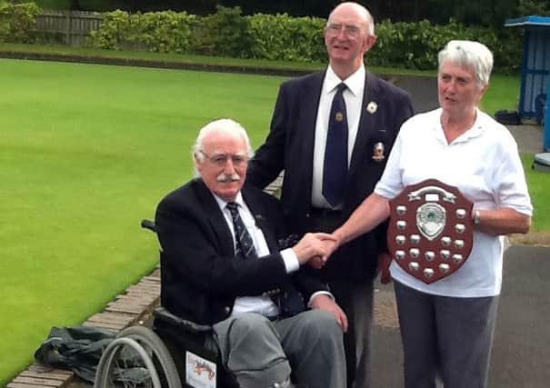 June McClure presents the Cecil McClure Memorial Trophy to George Burns, tournament organiser. Also included is City of Derry Bowling Club President Charles McDaid.