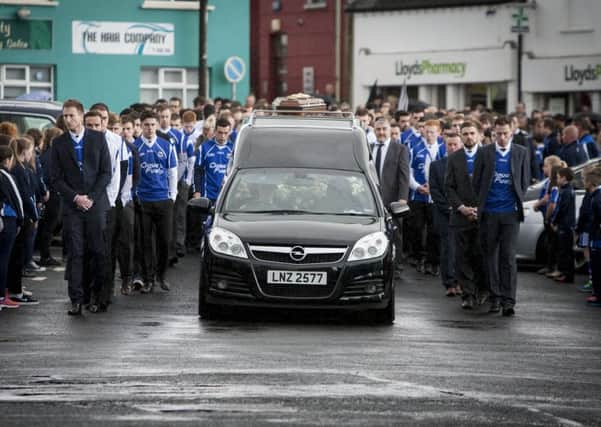 A sea of blue shirts flank the coffin and stand 'guard of honour' as the remains of Conall Kerrigan make their way into the grounds of St. Patrick's Church, Claudy yesterday morning for Requiem Mass. DER3415MC004