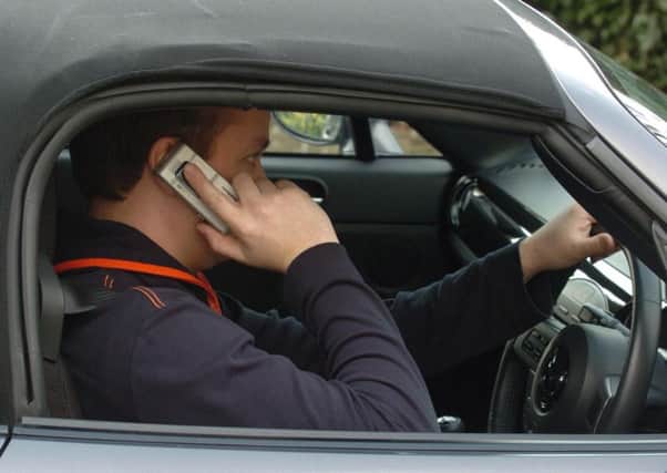 Man using his mobile phone while driving.