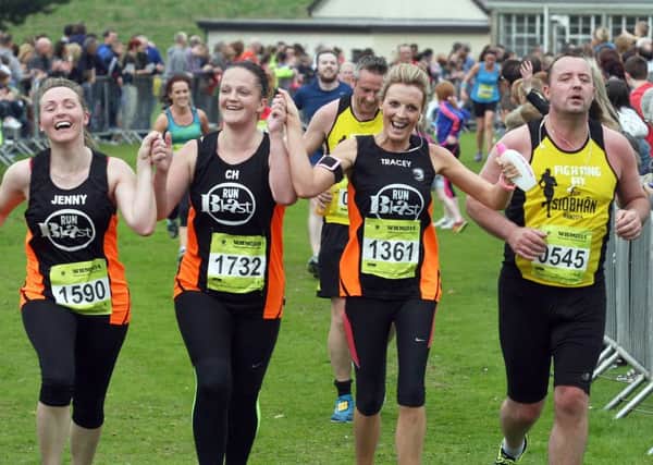 Members of Run Blast, Tracey Doherty, Colleen Harley and Jenny Mullan, join hands as they cross the finishing line in the Waterside Half Marathon.  3714-0048MT.