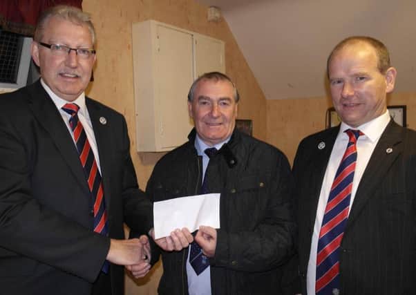 Bobby Lutton (centre, Lurgan Mechanics' Institute Sports and Social Club) presents a sponsorship cheque to the Mid-Ulster Football Association's Norman Livingston (left, chairman) and Colin McCullough (treasurer).