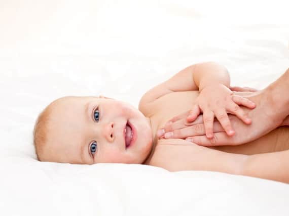 Masseuse massaging little baby girl, shallow focus