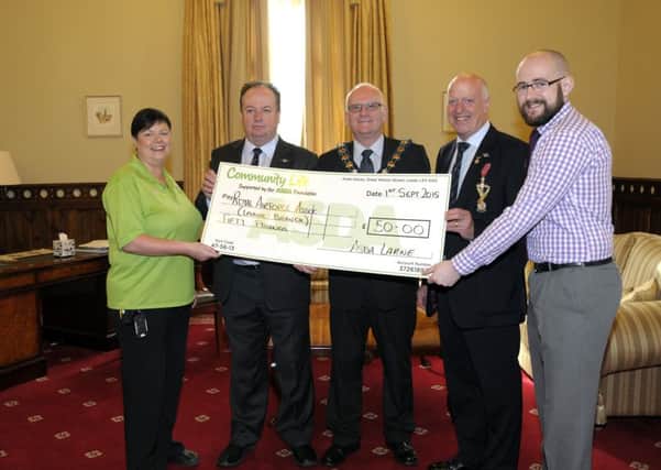 Catherine McCallion, ASDA Community Champion and Niall Keyes, ASDA store Manager present Michael O'Toole and John Kirkpatrick from Larne Branch of the Royal Air Force Association. with a cheque for £50 as a result of ASDA's Green Disc Appeal, also pictured is MEA Borough Council's Mayor, Cllr Billy Ashe. INLT 35-232-AM
