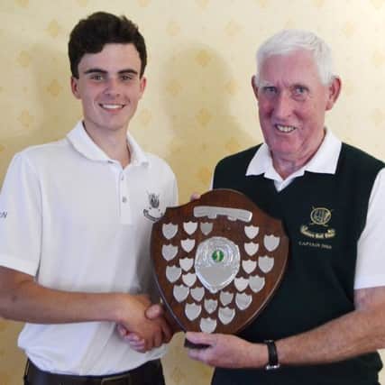 Lisburn's Juvenile Captain Mark McNellis presents Club captain John Boyd with the Ferris Trophy.